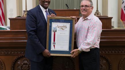 Assemblymember Cooper presenting Assembly Resolution to Mitchell E. Slate