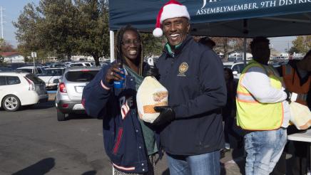 Assemblymember Cooper handing out turkey to constituents